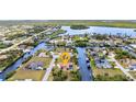Expansive aerial view of the waterfront community with a single-Gathering home, boat dock, and lush landscaping at 4473 Sweetbay St, Port Charlotte, FL 33948