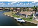 Aerial shot of the backyard with boat dock, screen enclosed pool, landscaping, and waterfront views at 571 Port Bendres Dr, Punta Gorda, FL 33950