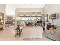 Bright living room with tile flooring, comfortable seating, a grand piano, and views of the screened pool area at 584 Toulouse Dr, Punta Gorda, FL 33950