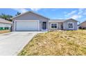 Single-story home featuring a neutral color scheme, an attached garage, and a well-maintained lawn at 6344 Hera St, Englewood, FL 34224