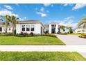 Beautiful single-Gathering home featuring a lush lawn and a paved driveway under a blue sky with clouds at 8968 Artisan Way, Sarasota, FL 34240
