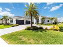 Beautiful single-Gathering home featuring a three-car garage and a paved driveway under a blue sky with clouds at 8968 Artisan Way, Sarasota, FL 34240