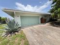 Charming home featuring a two-car garage, well-maintained driveway, and landscaped yard with beautiful plants at 931 Juno Dr, Punta Gorda, FL 33950
