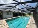 Enjoy the outdoors under this home's screened-in pool with a brick deck and beautiful blue water at 931 Juno Dr, Punta Gorda, FL 33950