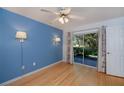 Light and airy bedroom with hardwood floors, bright blue accent wall, and access to an outdoor patio at 1051 Forrest Nelson Blvd # 104, Port Charlotte, FL 33952