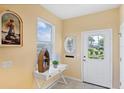 Bright foyer featuring a decorative table, a window with blinds, and a white front door at 1085 Jonah Dr, North Port, FL 34289