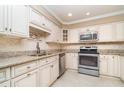 Bright kitchen featuring stainless steel appliances, granite counters, tile backsplash, and ample storage at 1326 Wesley Dr # 123, Punta Gorda, FL 33950