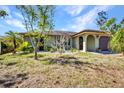 Charming single-story home featuring a well-manicured lawn and lush landscaping at 1357 Le Pera Rd, Englewood, FL 34223