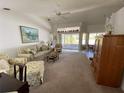 Spacious living room with neutral carpet, ceiling fan, and large windows letting in natural light at 21342 Walling Ct, Port Charlotte, FL 33954