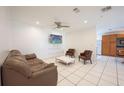 Cozy living room with tile floors, ceiling fan, and a view into the kitchen at 2230 Harbor Blvd, Port Charlotte, FL 33952