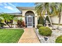 Inviting front entrance with a brick walkway, manicured garden, and a charming fountain at 23104 Turnbull Ave, Port Charlotte, FL 33954