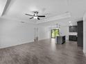 Open-concept living room featuring wood-look tile floors and modern lighting fixtures at 2372 Bonanza Ln, North Port, FL 34286