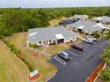 Beautiful aerial view of the property showing landscaping, parking, and surrounding wooded areas at 25068 Harborview Rd # 1B, Punta Gorda, FL 33980
