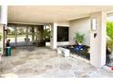 Condo lobby entrance with tiled floor, stone bench, decorative plants, and glass doors at 25188 Marion Ave # F307, Punta Gorda, FL 33950