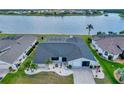 Aerial view of a one-story home with a screened pool and a beautiful lake view from the backyard at 25319 Vantage Ln, Punta Gorda, FL 33983