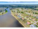 Scenic aerial view of a waterfront community with homes lining the riverfront and lush greenery at 25319 Vantage Ln, Punta Gorda, FL 33983