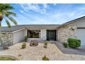 Close-up view of the home's front entrance with rock landscaping and a stone facade at 25319 Vantage Ln, Punta Gorda, FL 33983