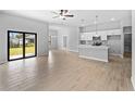 Bright living room showcasing an island kitchen, tile floors, and sliding glass doors to the backyard at 4453 Lagoon Ter, North Port, FL 34286