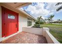 Welcome home to a bright, red front door with brick accents and lush landscaping framing the pathway at 530 Matares Dr, Punta Gorda, FL 33950