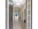 Inviting foyer showcasing neutral tones, tray ceilings, tile flooring and glass inserts in sidelight window for added sophistication at 8725 Amaretto Ave, Sarasota, FL 34238