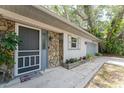 Inviting entrance to a single-story home with a stone accent wall and a gray front door at 1173 Belmar Ave, Port Charlotte, FL 33948