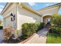 Home exterior featuring a brick walkway leading to the front door and manicured landscaping at 1230 Collier Pl, Venice, FL 34293