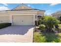 Home exterior showcasing a brick driveway, landscaped yard, and an attached two-car garage at 1230 Collier Pl, Venice, FL 34293