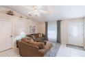 Cozy living room showing neutral walls, tiled floors, comfortable sofas, and transom window at 1381 Fargo St, Port Charlotte, FL 33952