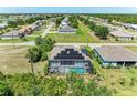 Aerial view of a home featuring a screened pool, solar panels, and neighborhood surroundings at 2636 Mauritania Rd, Punta Gorda, FL 33983