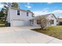 Two story home with a grey exterior, large front yard and an attached garage on a sunny day at 2776 Tusket Ave, North Port, FL 34286