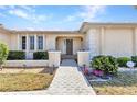 Inviting front entrance with paved walkway, lush landscaping, and decorative pillars at 3824 Aves Island Ct, Punta Gorda, FL 33950