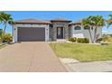 Beautifully landscaped single-Gathering home featuring a brown tile roof, brown garage door, and elegant stone entrance at 4001 La Costa Island Ct, Punta Gorda, FL 33950