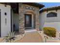 Elegant stone archway frames the front door of this lovely home, accented by lush landscaping at 4001 La Costa Island Ct, Punta Gorda, FL 33950