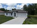 Inviting single-Gathering home featuring a concrete driveway leading to an attached garage at 4127 Snowdrop St, North Port, FL 34288