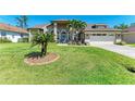 Beautiful single-story home with manicured front lawn, palm trees, and an attached two-car garage at 420 Wabash Ter, Port Charlotte, FL 33954