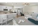 Open-concept kitchen featuring stainless steel appliances, white cabinetry, and an eat-in island at 4343 Killdeer Ter, North Port, FL 34288