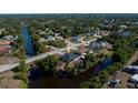 Aerial view of a home backing onto a canal in a quiet neighborhood surrounded by lush greenery at 7225 Sea Mist Dr, Port Charlotte, FL 33981