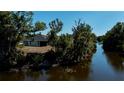 Scenic aerial view of the property backing onto a tranquil waterway with lush greenery and mature trees at 7225 Sea Mist Dr, Port Charlotte, FL 33981