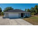 Exterior view of a well-maintained one-story home featuring a spacious driveway and attached garage at 7225 Sea Mist Dr, Port Charlotte, FL 33981
