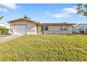 A quaint single-story home with a manicured lawn and an attached garage at 8172 Trionfo Ave, North Port, FL 34287