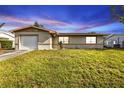 A charming single-story home with well-kept lawn, lit by a beautiful twilight sky at 8172 Trionfo Ave, North Port, FL 34287