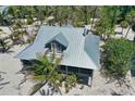 Aerial view of charming coastal home featuring a metal roof and expansive wraparound porch at 8754 King St, Placida, FL 33946