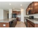 Modern kitchen with granite countertops, stainless steel appliances, and ample cabinet space at 10204 Carloway Hills Dr, Wimauma, FL 33598