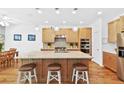 The kitchen has an island, wooden cabinets, stainless steel appliances, and plenty of counter space and lighting at 12857 Pinnacle Ln, Venice, FL 34293