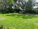 Expansive backyard with lush green grass and mature trees, perfect for outdoor activities at 1457 Sheehan Blvd, Port Charlotte, FL 33952