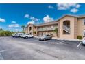 Condo building showing parking area, tan paint, stairs to the second story and manicured landscaping at 175 Kings Hwy # B2 1522, Punta Gorda, FL 33983