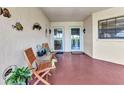 Inviting porch with chairs and decor, leading to double glass doors at 23465 Harborview Rd # 842, Port Charlotte, FL 33980