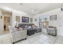 Comfortable living room with tile flooring, a ceiling fan, and natural light from a window at 242 Seminole Nw Blvd, Port Charlotte, FL 33952