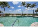 Relaxing community pool with palm trees and waterfront views in a serene setting at 5114 Melbourne St # A202, Punta Gorda, FL 33980