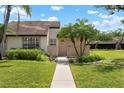 Lovely home featuring a well-manicured lawn and lush landscaping, including mature palm trees and verdant shrubs at 5390 Brassy Loop, North Port, FL 34287